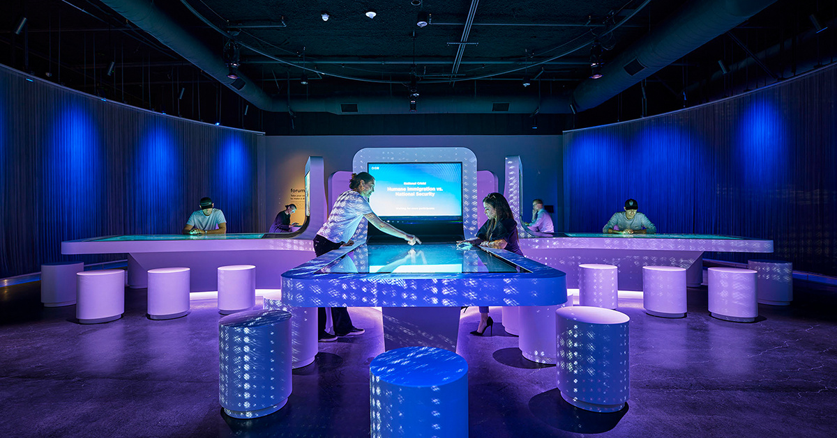 Two visitors playing with a interactive board 