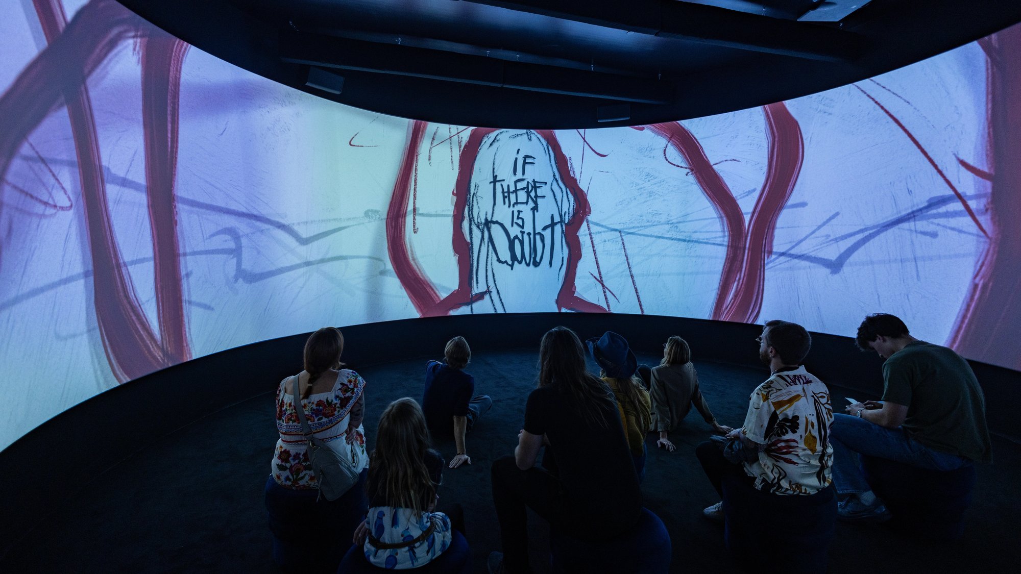 Group of people look at the curved screen projection in the Black Box