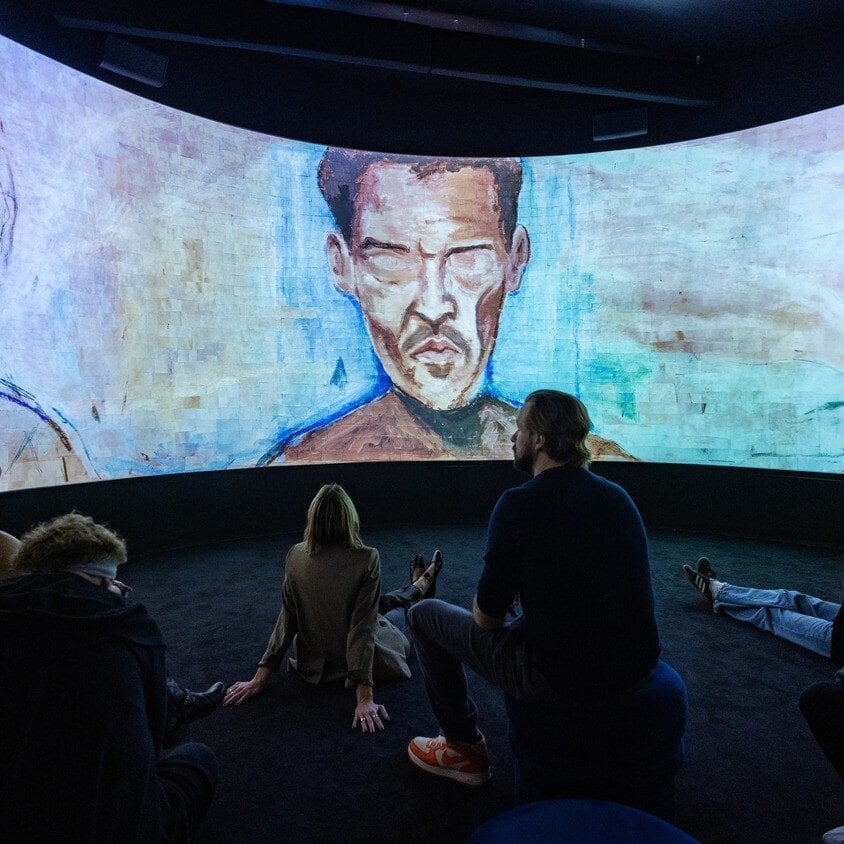 Group of people looking at a video wall of Johnny Depp