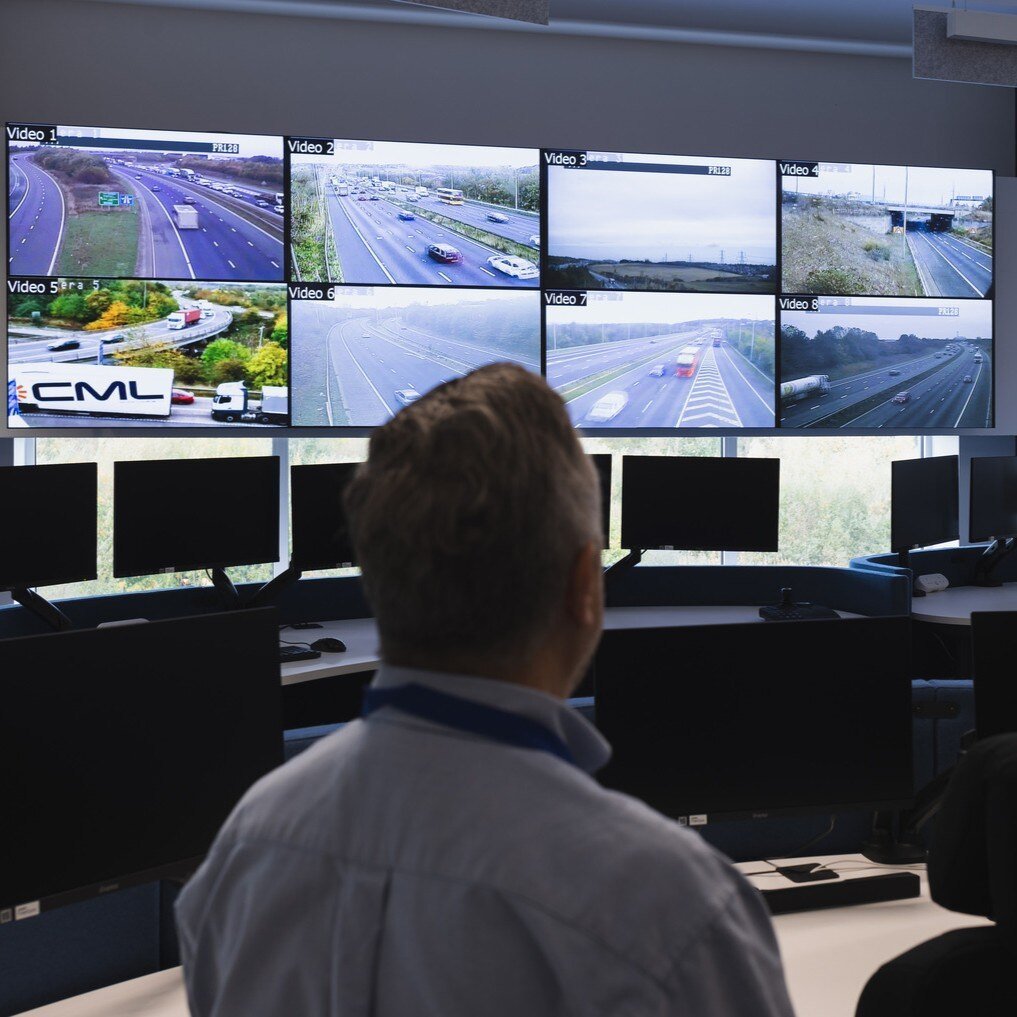 Man looking at the screen wall in front of him 