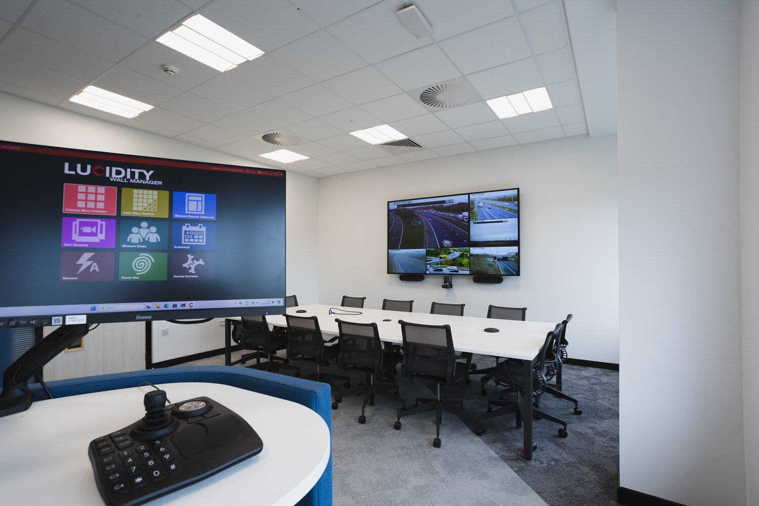 The conference room with a table and a side monitor used to control the main tv