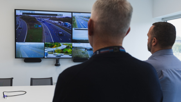 Two men looking at the screen in the conference room