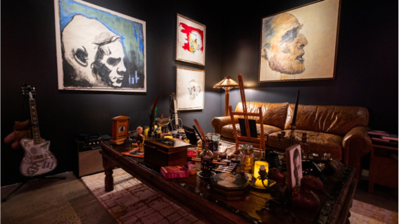 A gallery space that mimics the living room where Johnny Deep created paintings with a couch and table 