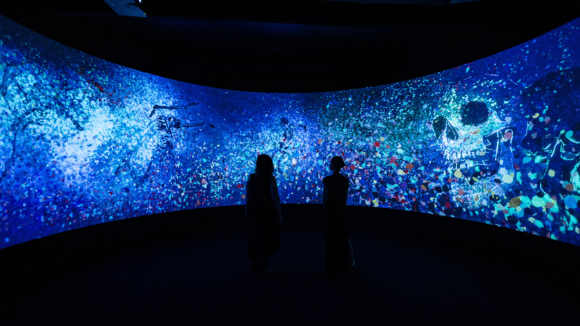 People looking at a curved projection wall that displays Johnny Deeps artwork