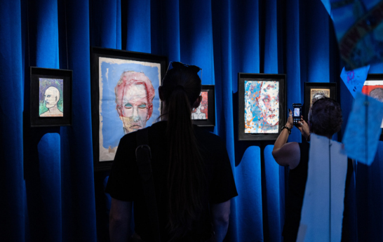 Fans looking at artwork on a blue curtained wall