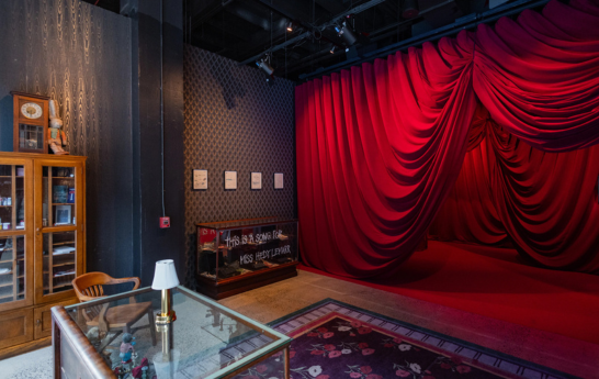 A gallery space of Johnny Depp leading into a curtained area